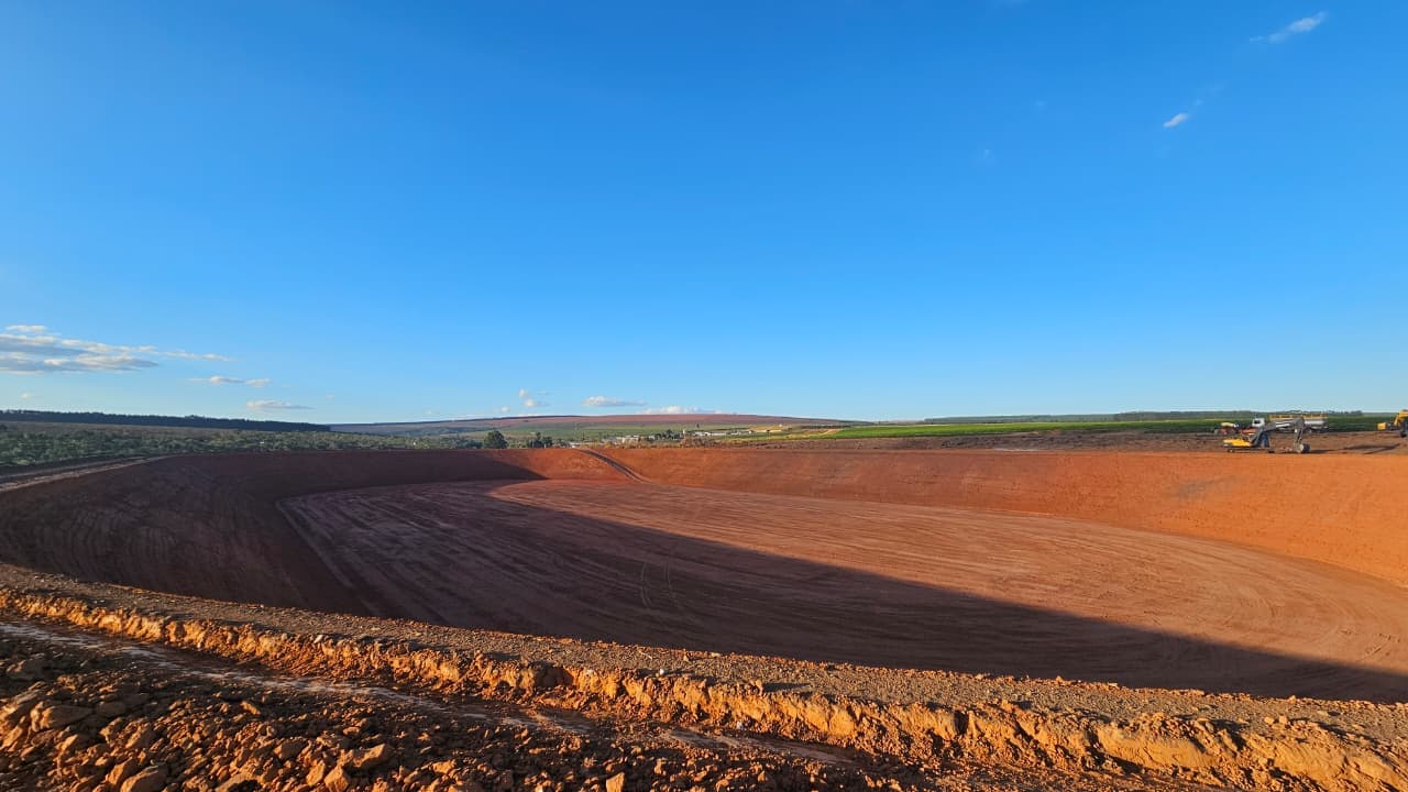Vista panorâmica de reservatório off-stream em fase de conformação de fundo e taludes — Exxata Agro