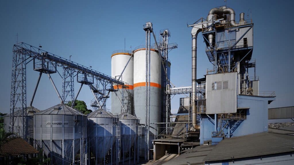 Foto panorâmica externa da fábrica da CCPR em Contagem/MG com prédios operacionais modernos e pátio pavimentado.